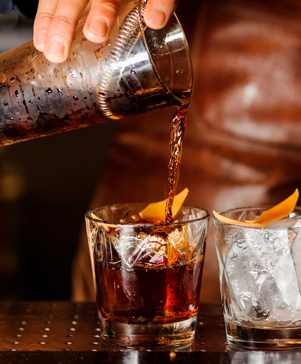 a hand pouring a dark drink