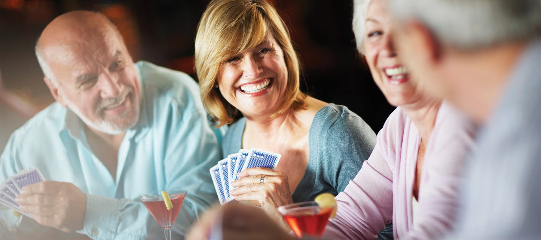 four seniors enjoying a table game